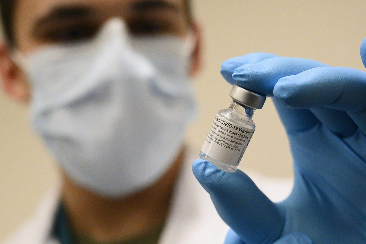 Army Spc. Angel Laureano holds a vial of the COVID-19 vaccine, Walter Reed National Military Medical Center, Wikimedia Commons