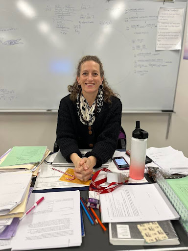 Photo shows Ms. Cabral sitting at her desk. Photo courtesy of Enes Damkaci, '27